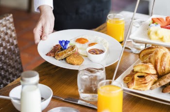Person Holding Round White Ceramic Plate with Food