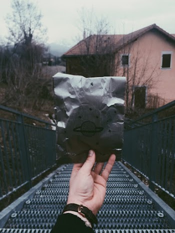 Person Holding Silver Pouch With Metal Staircase Background