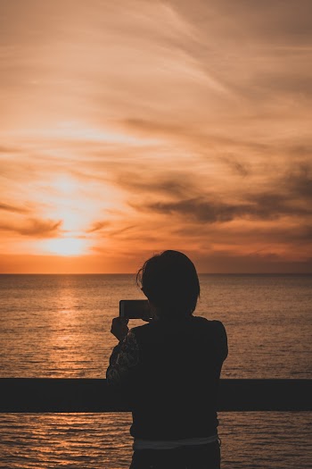 Person Holding Smartphone Beside Body Of Water