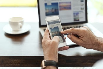 Person Holding Smartphone Sitting Near Table