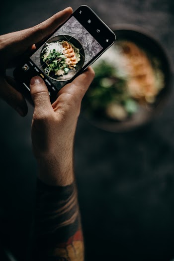 Person Holding Smartphone Taking Photo of Dish