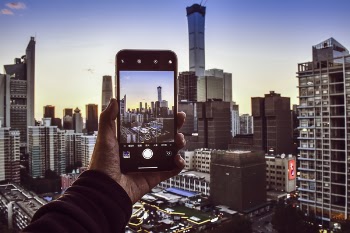 Person Holding Smartphone Taking Photo of High-rise Buildings