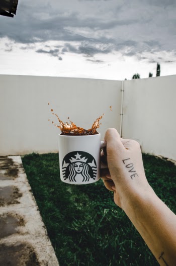 Person Holding Starbucks Cup With Brown Beverage