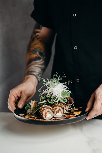 Person Holding Sushi on Plate