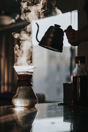 person holding teapot with boiled water