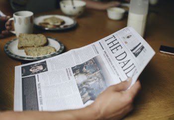 Person Holding the Daily Newspaper