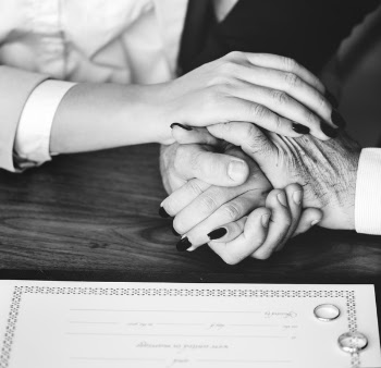 Person Holding Their Hands on Brown Wooden Table