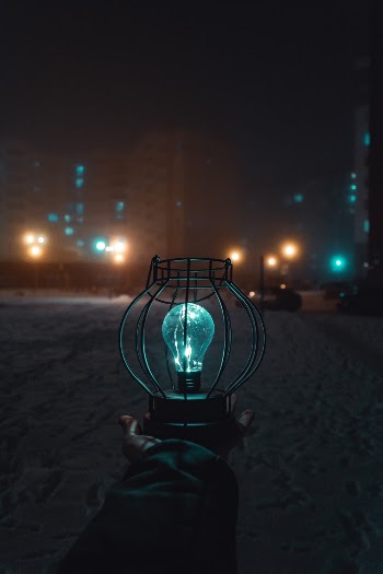 Person Holding Turned-on Light during Nighttime