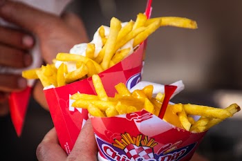 Person Holding Two Potato Fries Packs