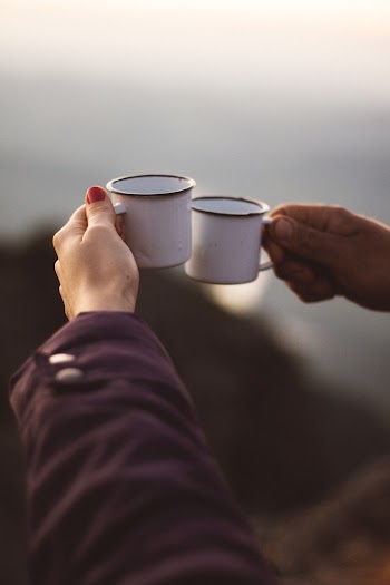 Person Holding Two White Cups