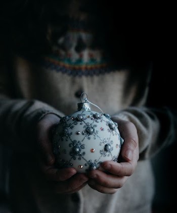 person holding white and grey ornament