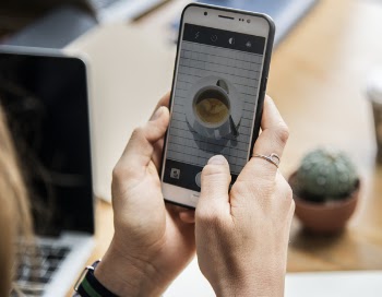 Person Holding White Android Smartphone With Black Rear Case