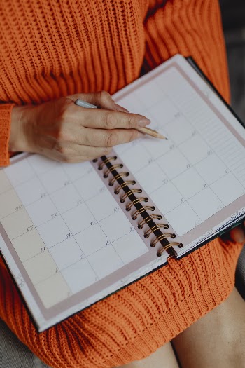 Person Holding White Book Planner