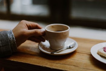 person holding white ceramic tea cup