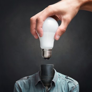 Person Holding White Light Bulb Beside Black Bulb Socket
