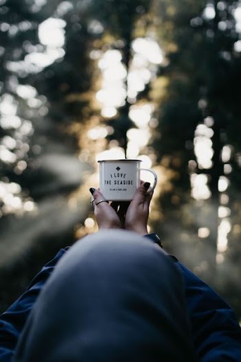 person holding white mug