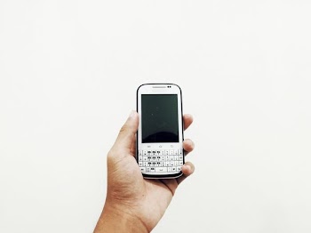person holding white QWERTY phone