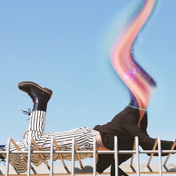 Person in Black Blazer, White and Black Striped Pants, and Black Boots