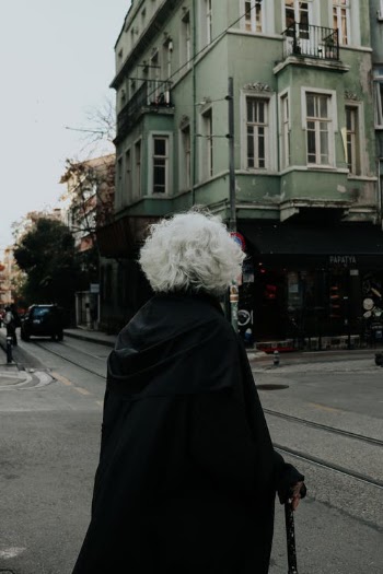 Person in Black Coat Standing on Sidewalk · Free Stock Photo