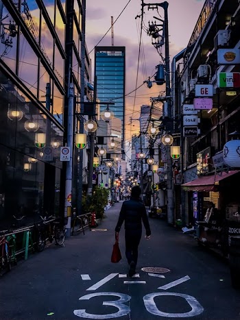 Person in Black Jacket Carrying Red Handbag