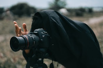 Person in Black Jacket Facing Black Canon Dslr Camera
