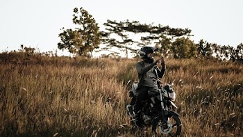 Person in Black Jacket on a Motorcycle on Brown Grass Field