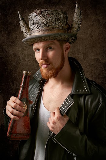 Person in Black Leather Biker Jacket Holding Brown Bottle
