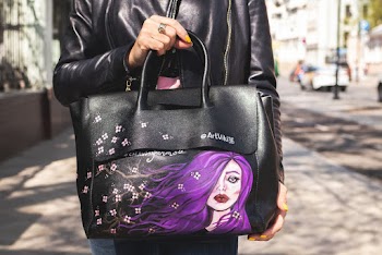 Person in Black Leather Jacket Carrying Black and Purple Leather Handbag