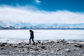 person in black pants walking on stone during daytime