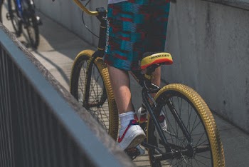Person in Blue and Red Shorts Riding Bicycle