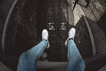 Person in Blue Denim Stonewashed Fitted Jeans and White Low-top Sneakers