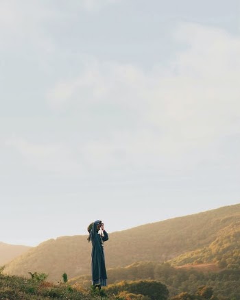 Person in Blue Dress Standing on Brown Hill · Free Stock Photo