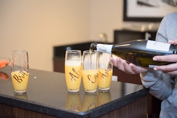 Person in Gray Sweater Pouring in Three Drinking Glasses Indoors