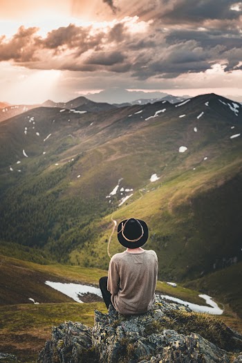 Person in Gray Top Sitting on Rock