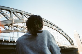 Person in Grey Shirt Near Grey Metal Bridge