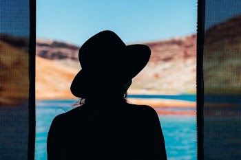 person in hat near body of water