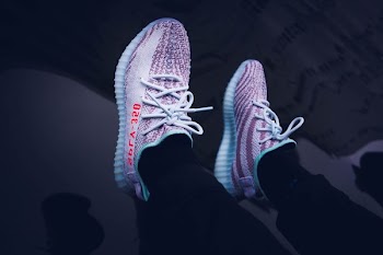 person in pair of black Adidas Yeezy Boost 350 V2 shoes