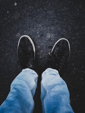 Person in Pair of Black Low-top Sneakers
