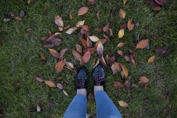 Person in Patent Black Low-top Shoes Standing Above Green Grass
