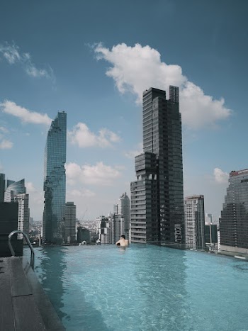 Person in Pool Looking at the Buildings