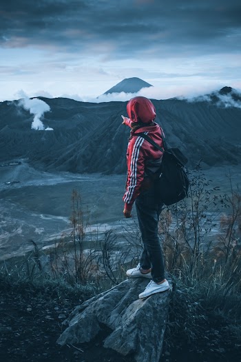 Person in Red Hoodie Standing on Rock