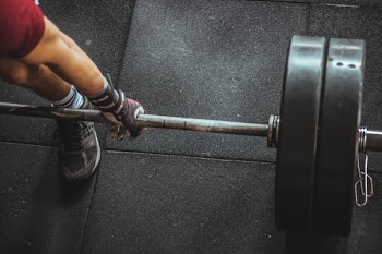 Person in Red Shirt Lifting a Barbell