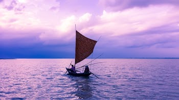 Person in Sailboat on Body of Water during Golden Hour