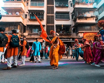 Person In Traditional Costume Holding Orange Flag