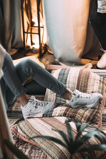 Person in White Fila Sneakers lying down in a bed  