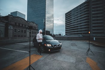 Person In White Hoodie Standing Near Black Vehicle
