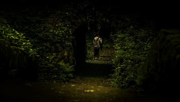 Person in White Top Standing Beside Archway