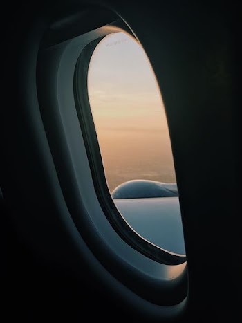 person inside plane at high altitude taking picture of left wing during daytime