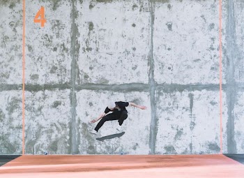 person jumped from board in front of gray wall during daytime