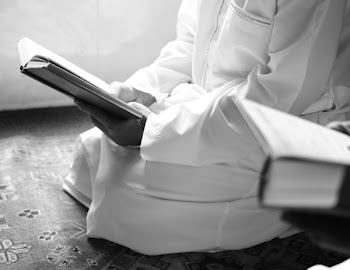 Person Kneeling Holding Book